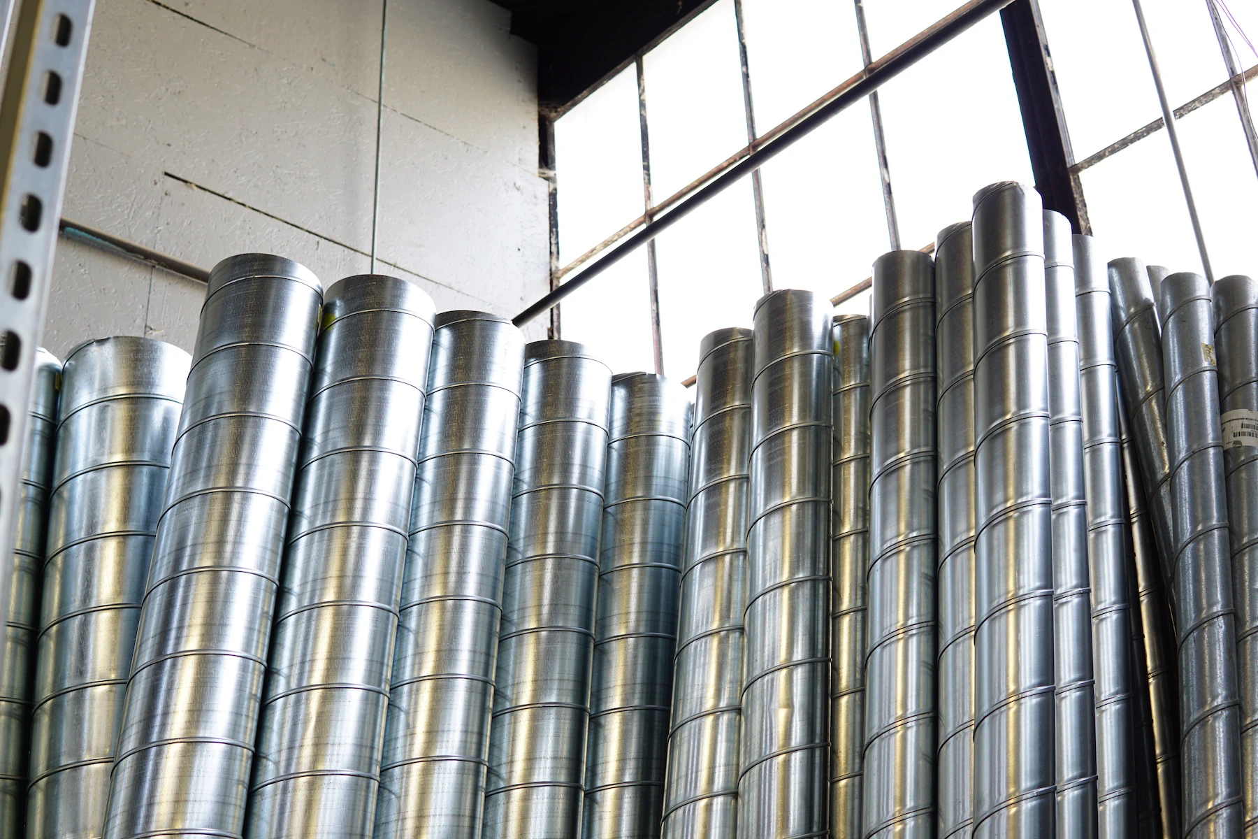 Rows of galvanized round duct pipes stored in the warehouse