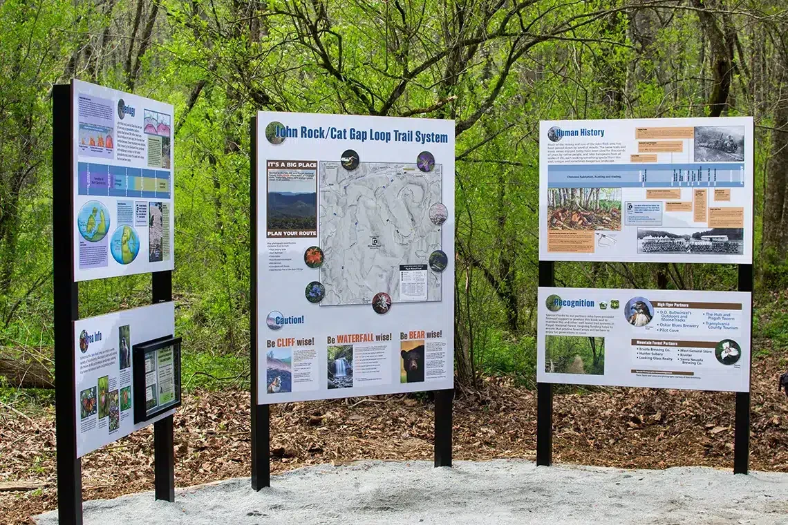 Trail information boards with a John Rock and Cat Gap Loop map, safety guidance, and local history
